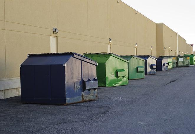 construction workers toss wood scraps into a dumpster in Attleboro